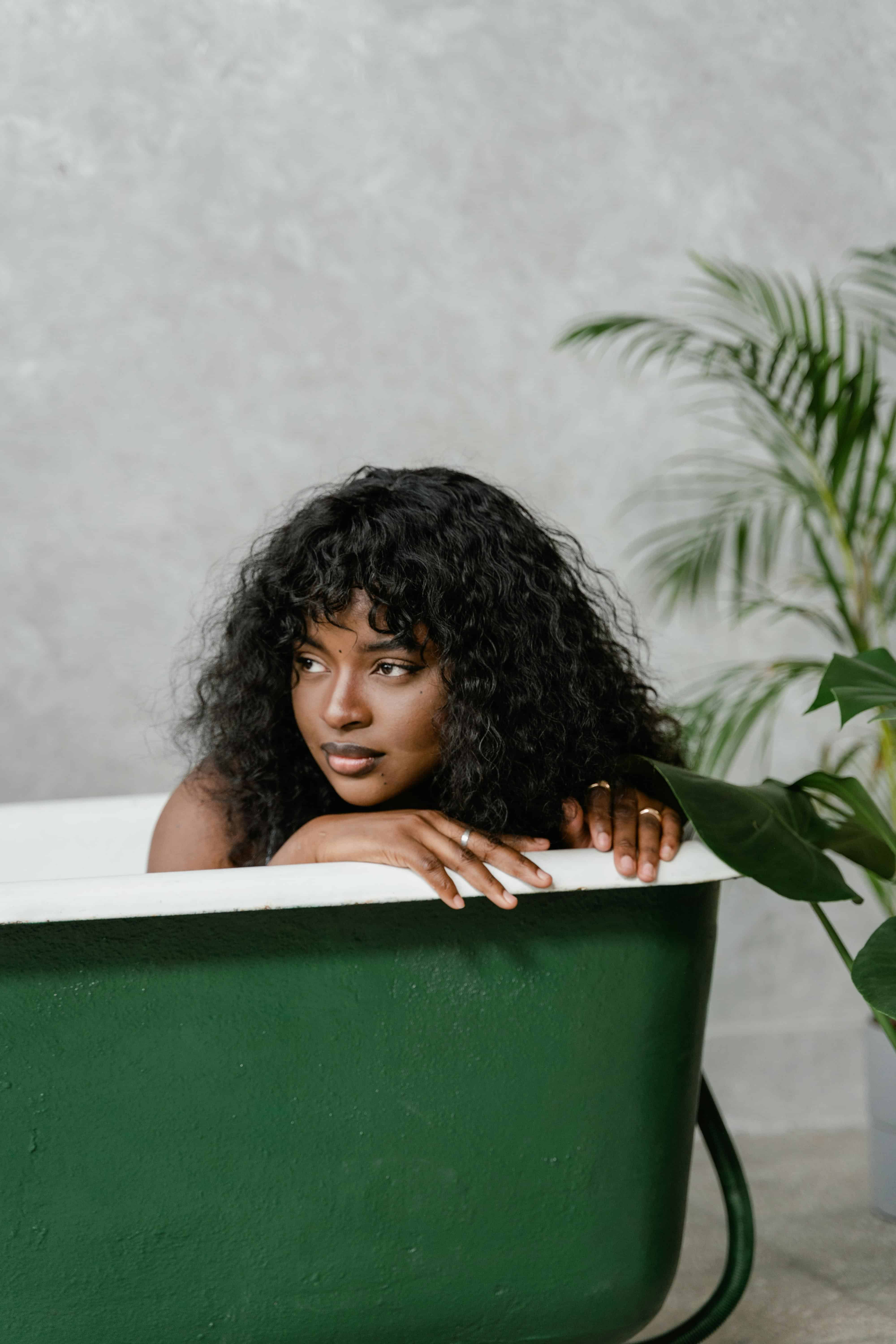 woman in a bathtub looking at something in the distance