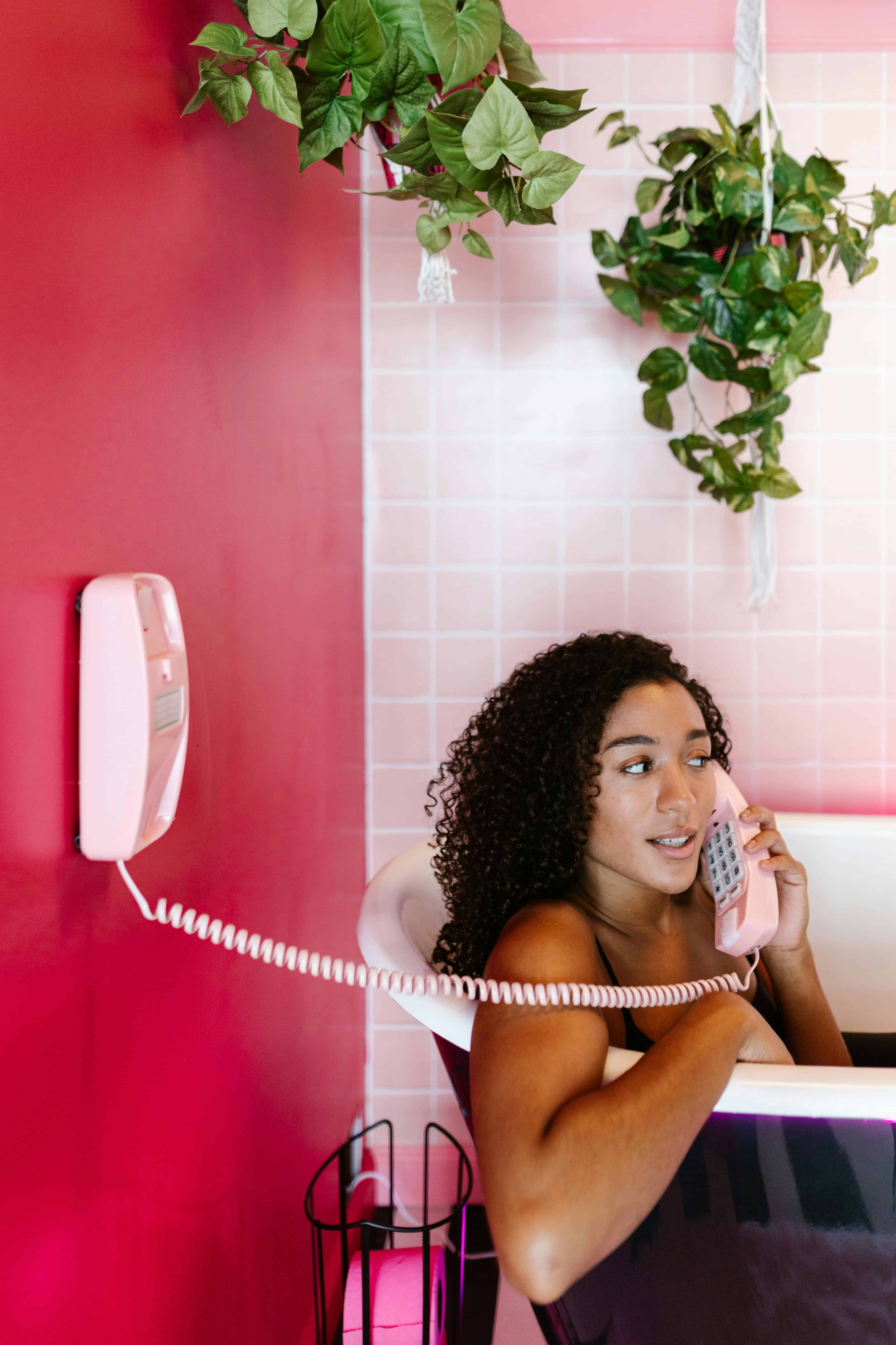 woman in a bathtub while being on the phone