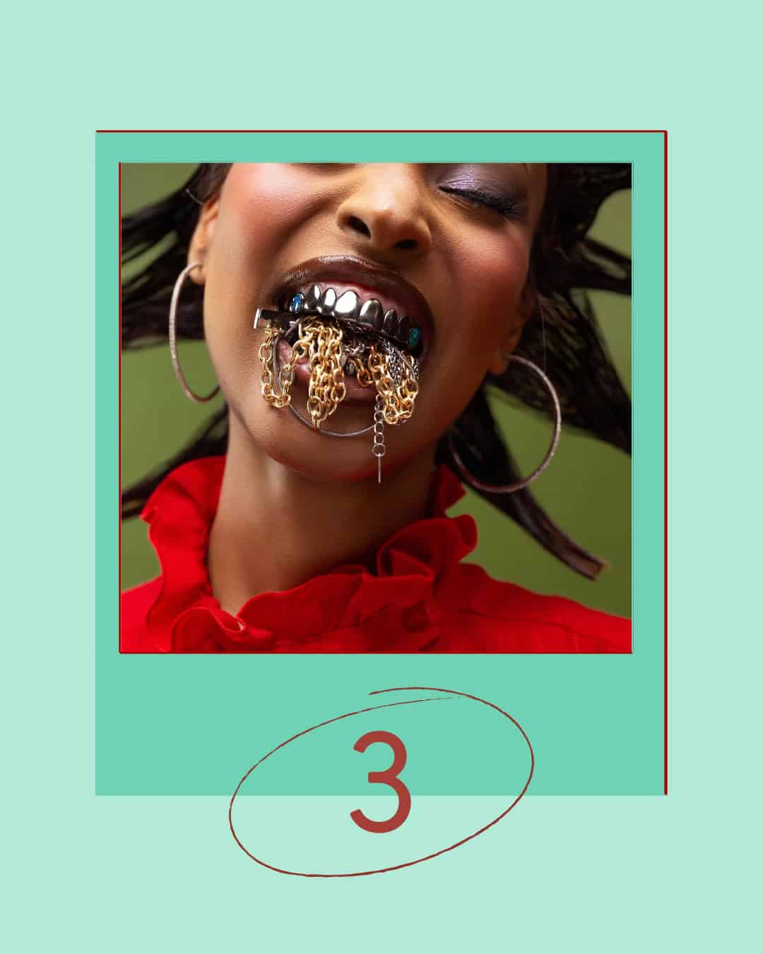 Person with silver grills and gold chains hanging from their mouth wearing a red ruffled top and large hoop earrings.
