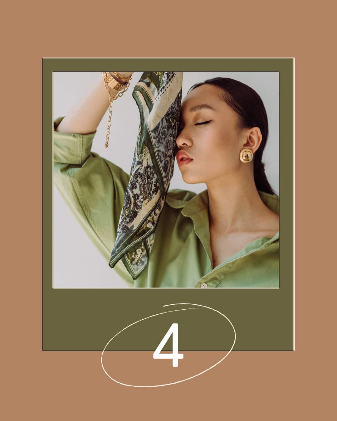 Woman in green shirt holding patterned scarf over half her face with closed eyes and gold earrings.