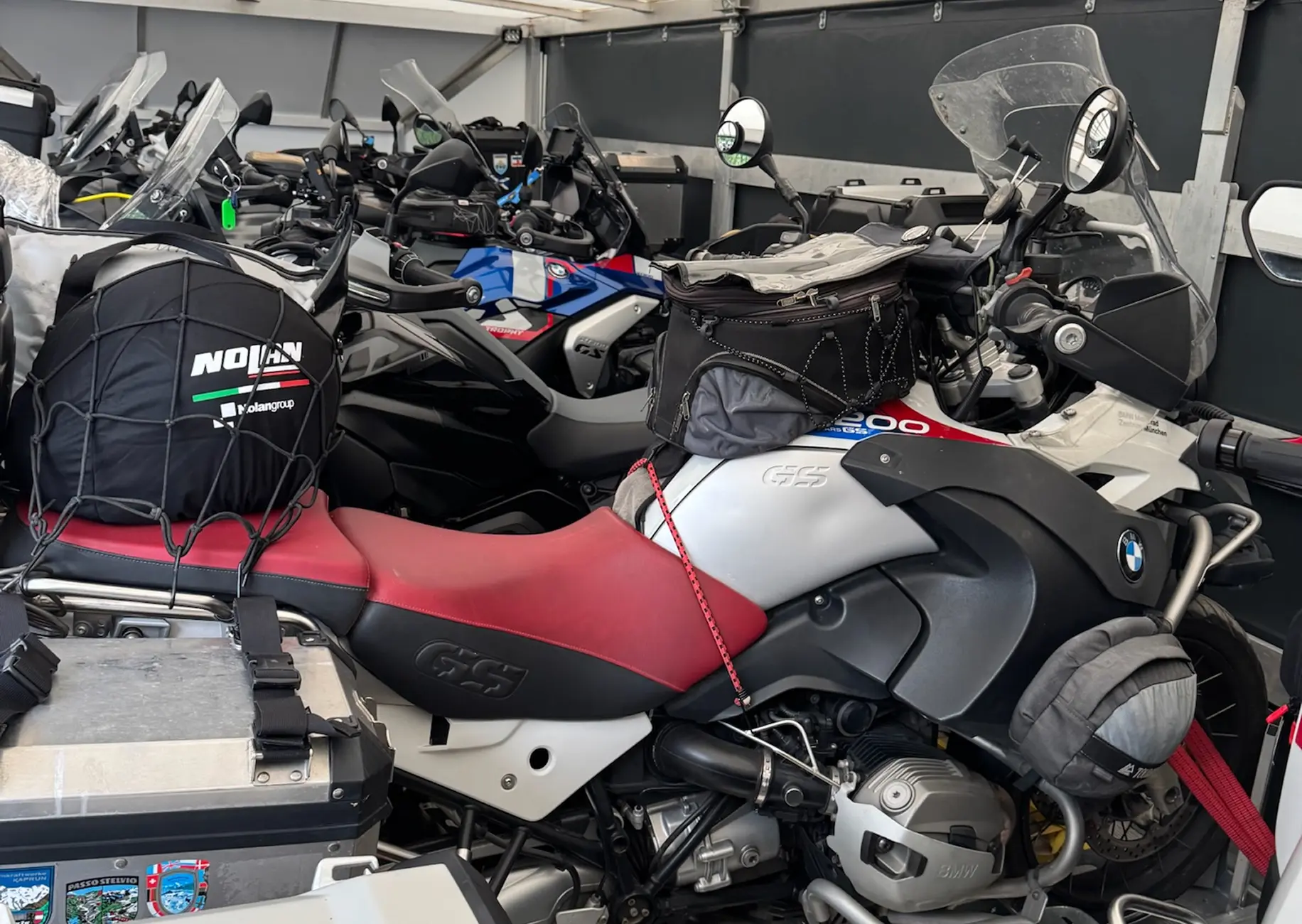 Sechs Motorräder und Gepäck sicher im geschlossenen Anhänger fixiert.