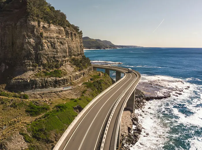 Tengerparti szikla mellett futó aszfalt út.