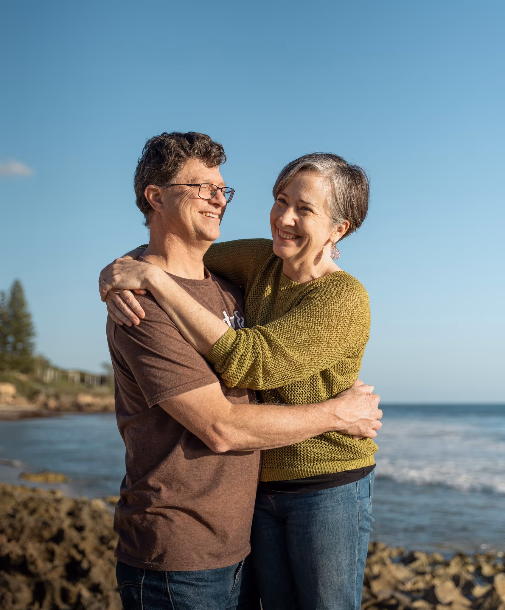 Beautiful couple's portrait by the sea at sunset