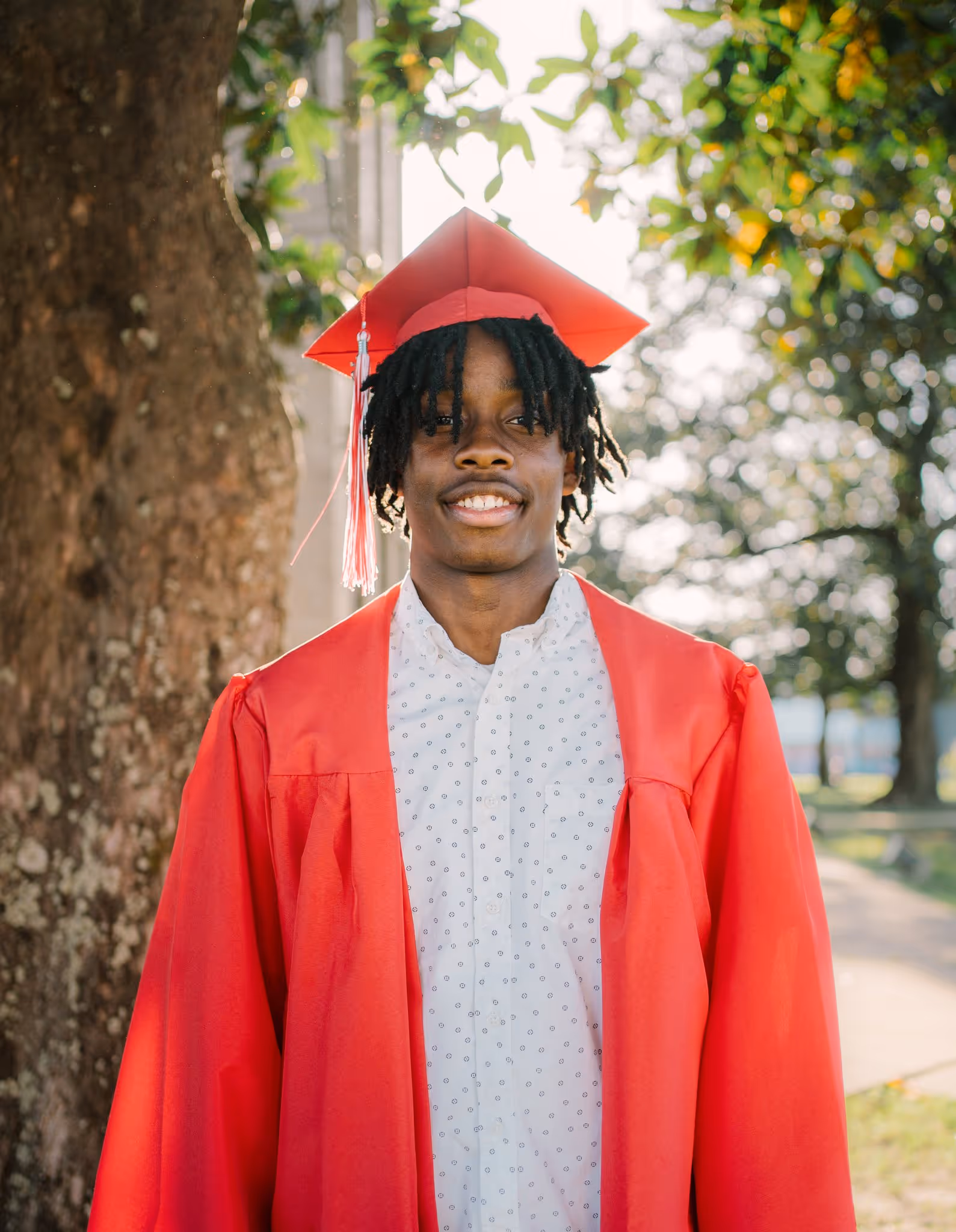 Portrait of a senior wearing a red gown.