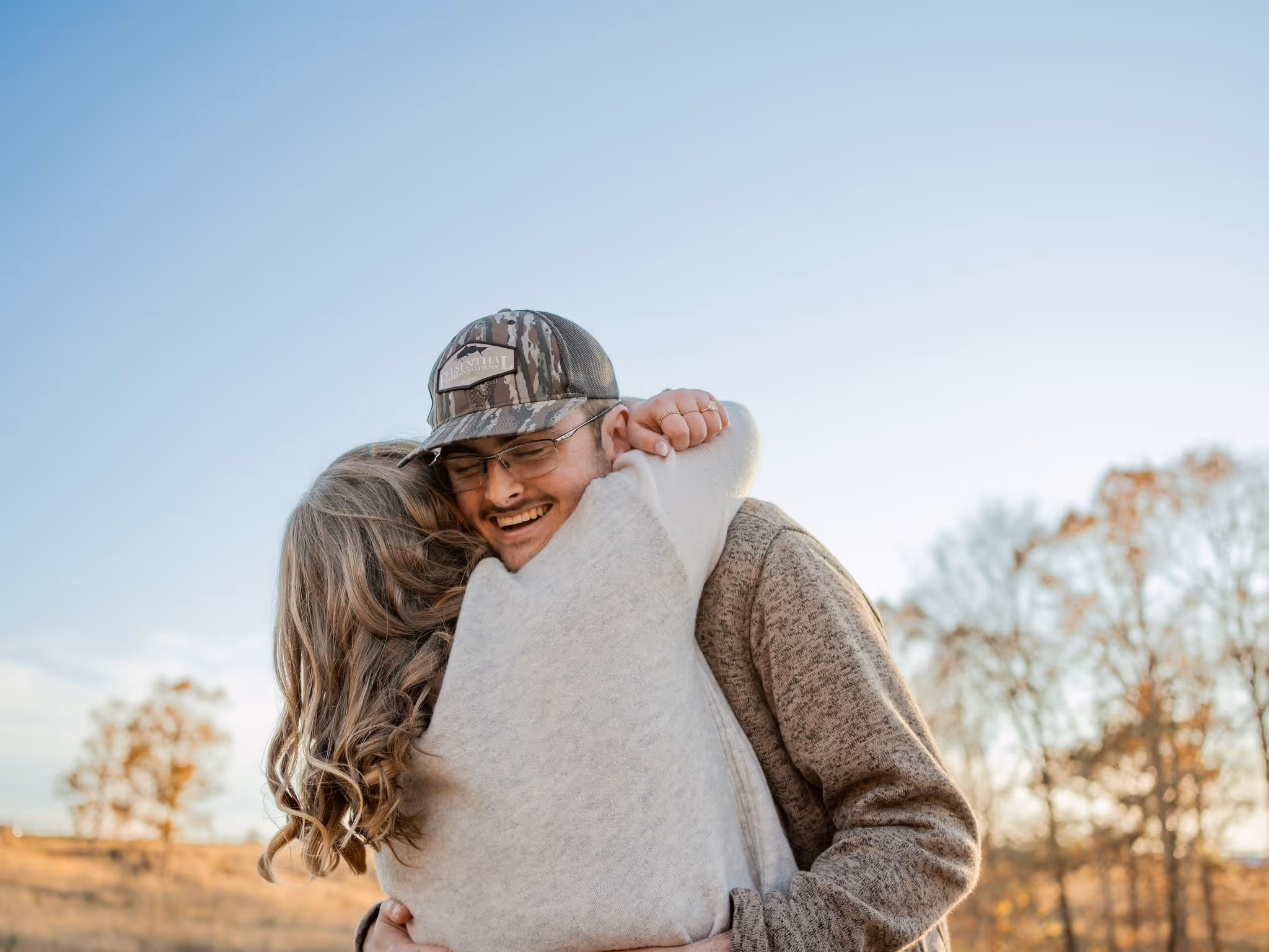 Couples portrait in a field at sunset