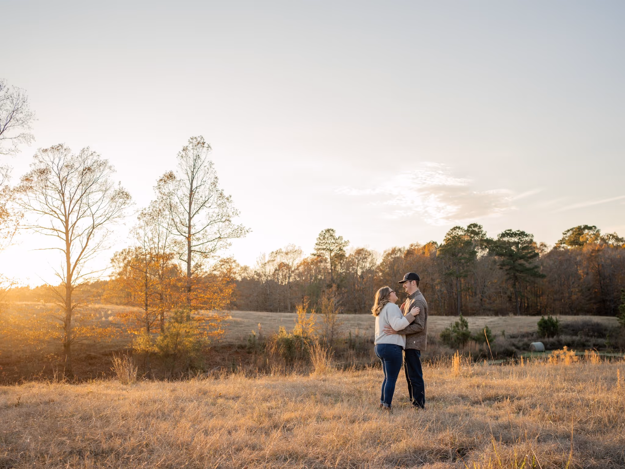 Couples portrait in a field at sunset