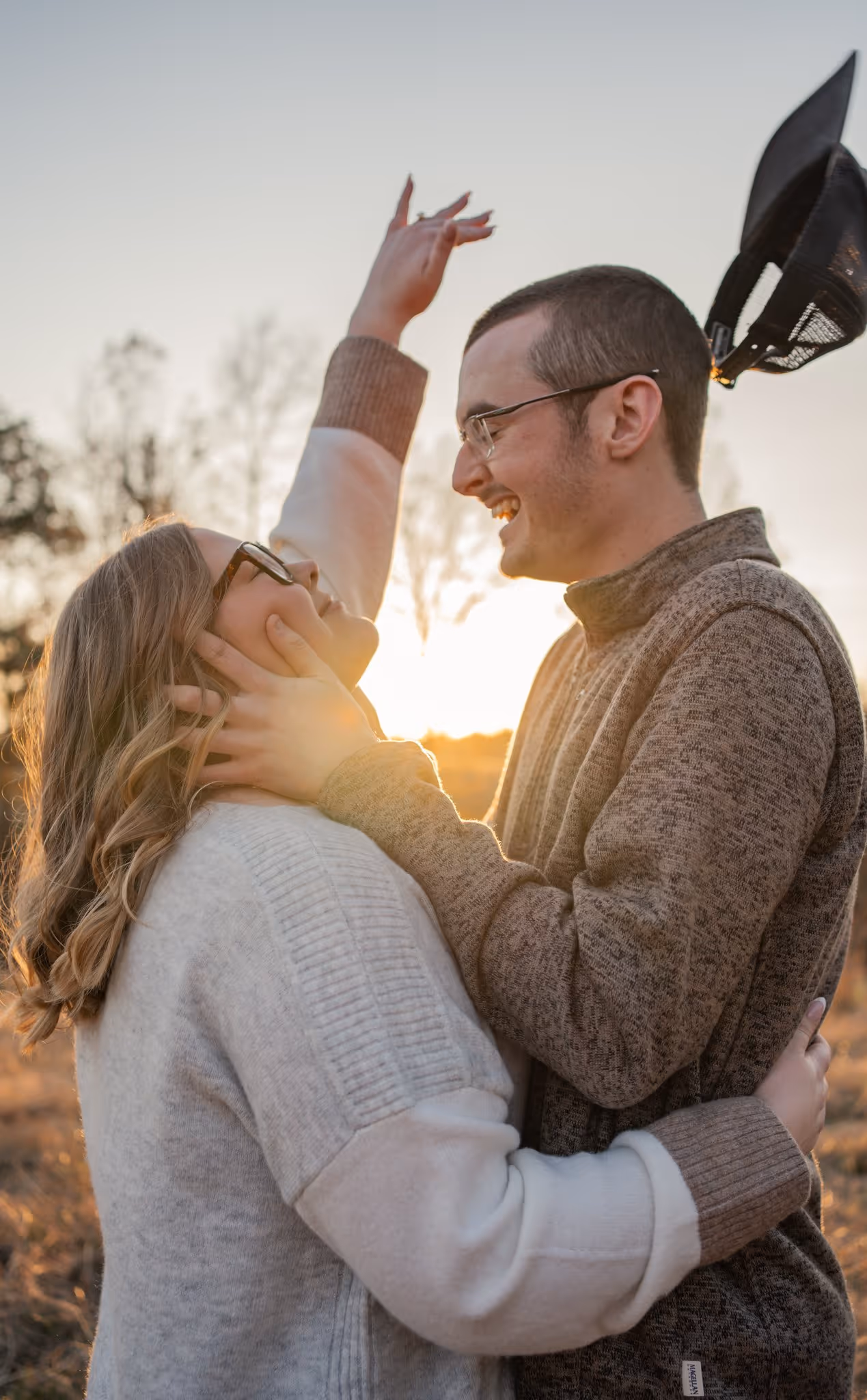 Couples portrait in a field at sunset
