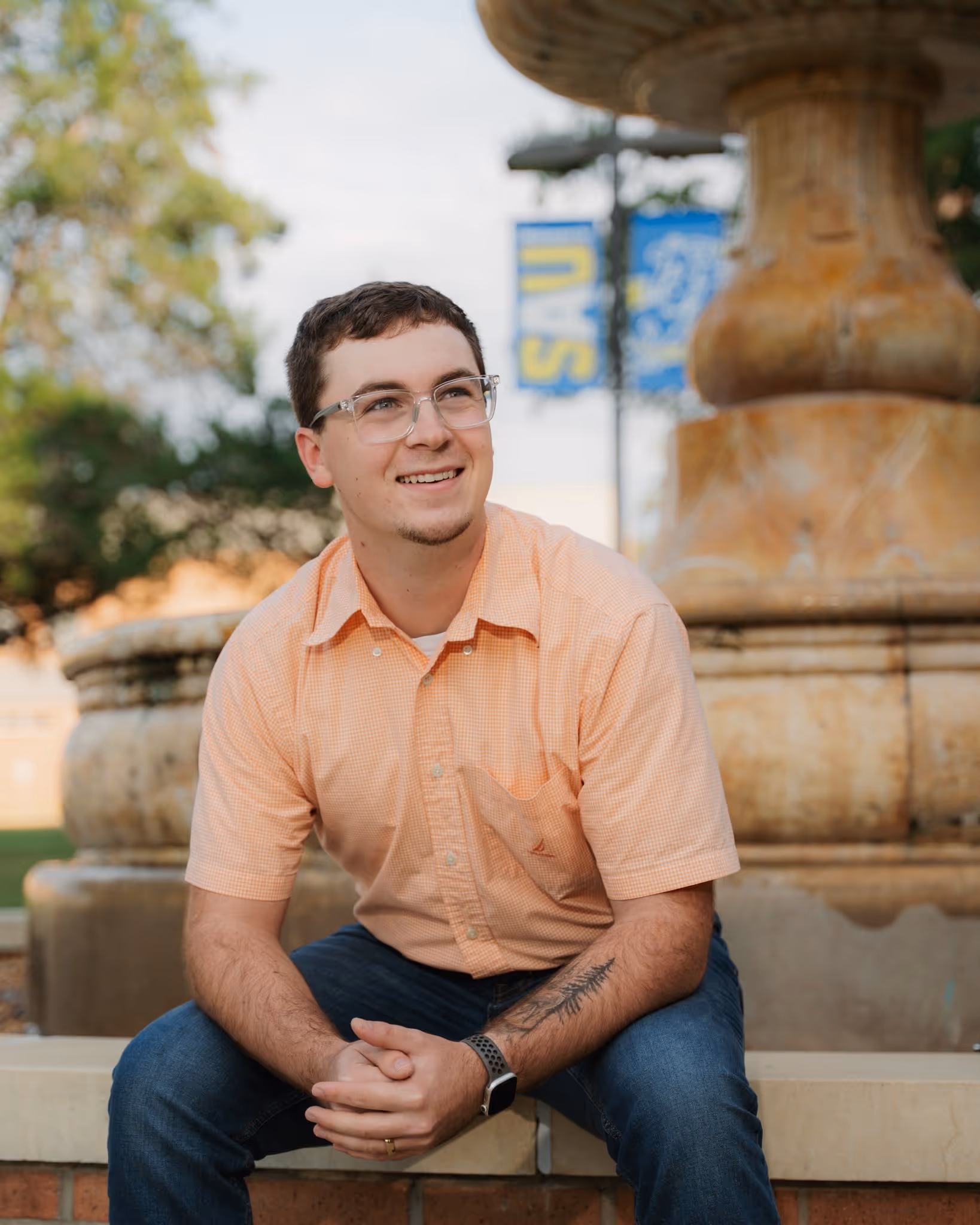 Portrait of a young man in front of a fountain