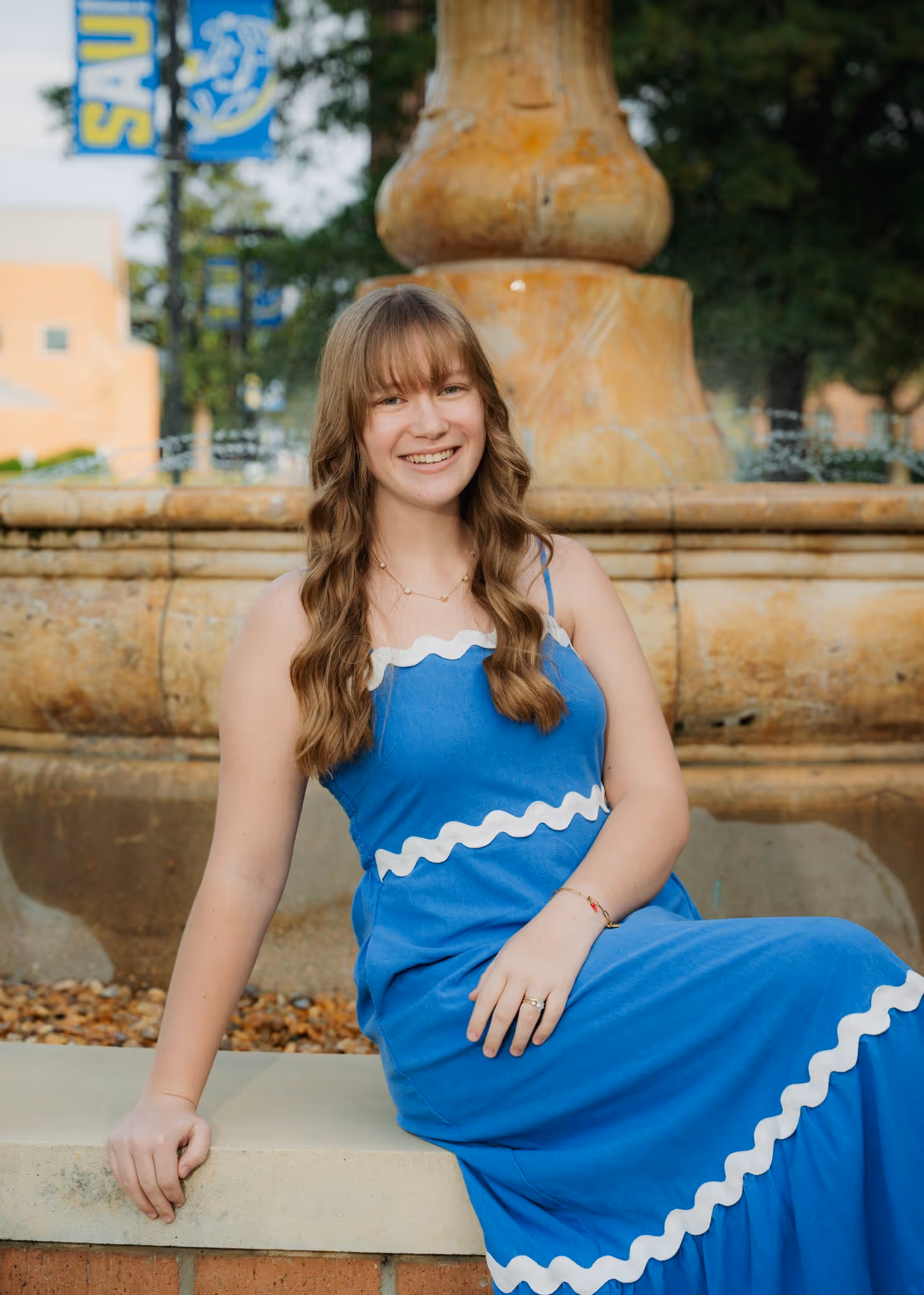 Portrait of a young woman in front of a fountain