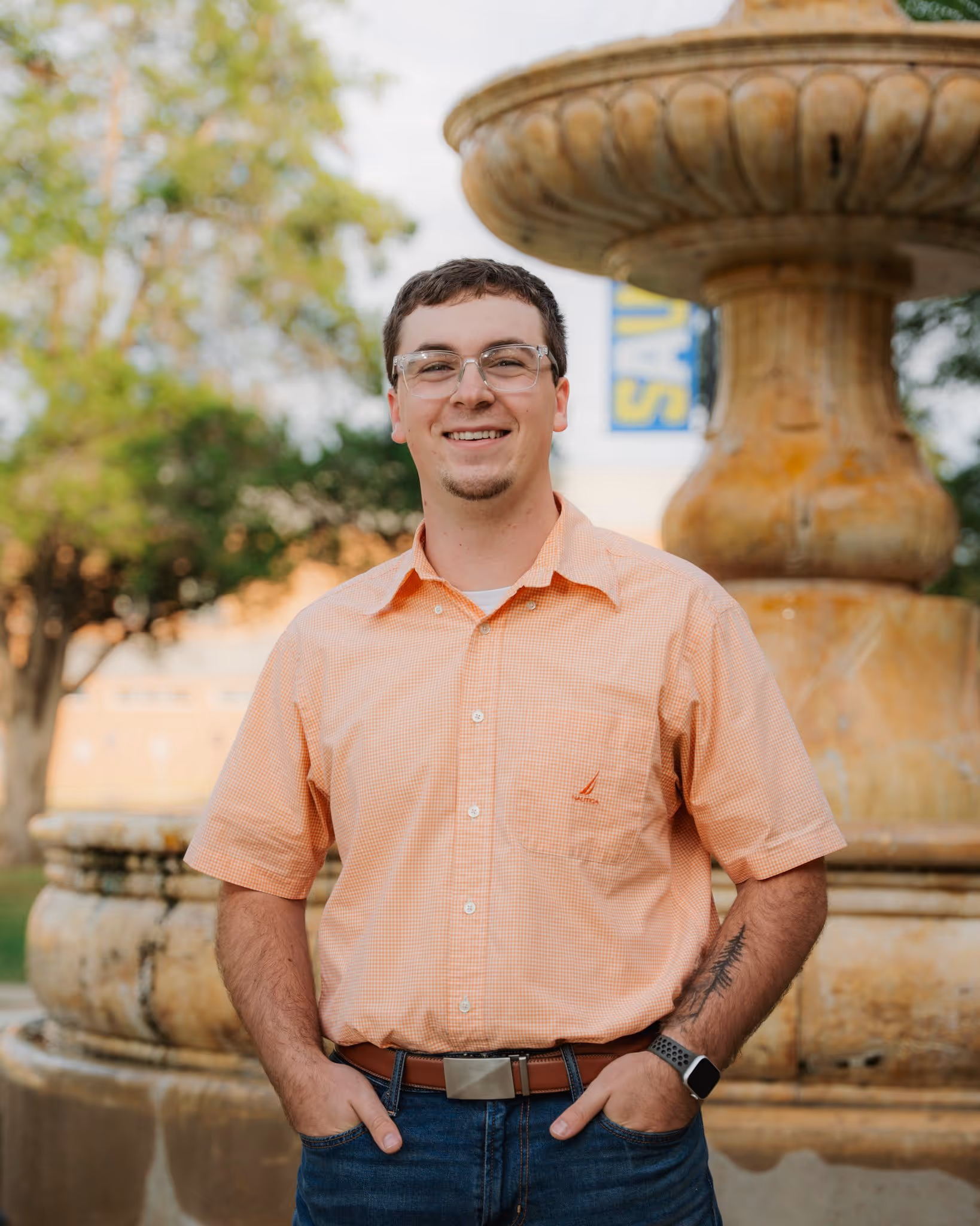 Portrait of a young man in front of a fountain