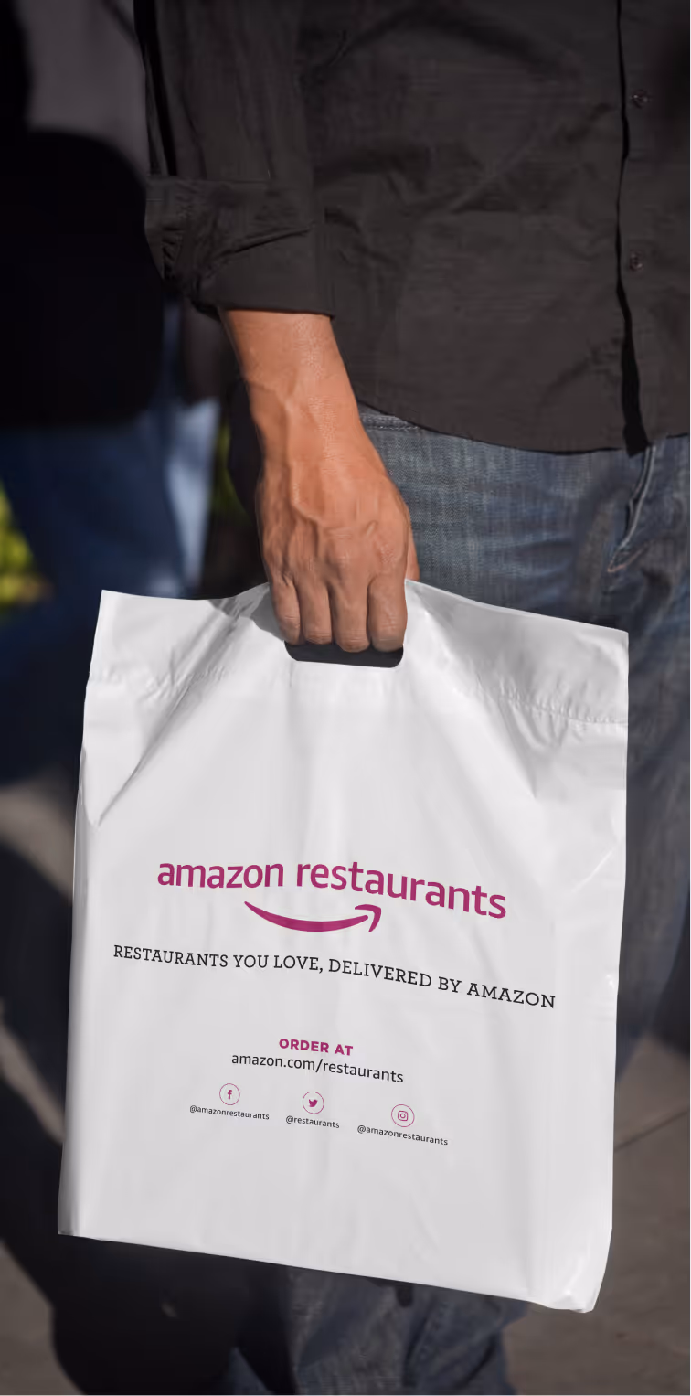 Person carrying white delivery bag with branding and ordering information.