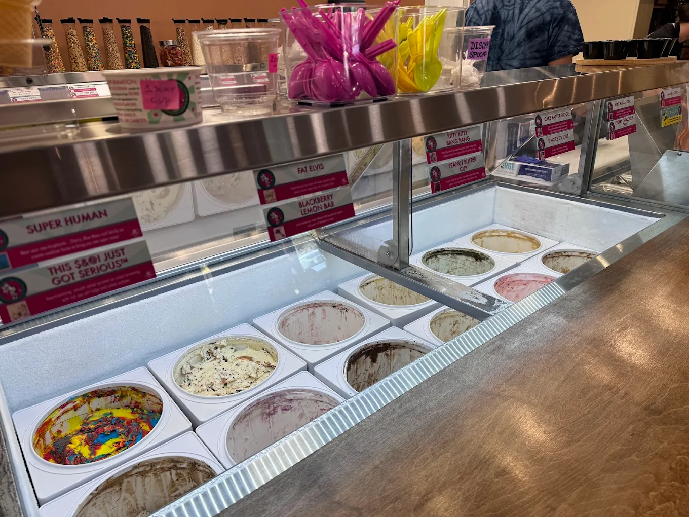 An ice cream shop counter displaying colorful tubs of ice cream.