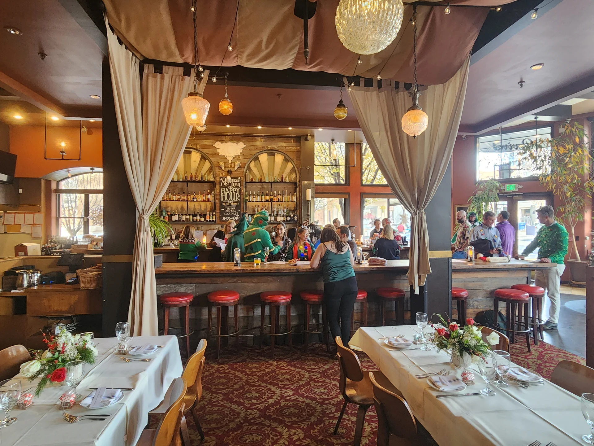 A restaurant with a bar and a woman in a green shirt.