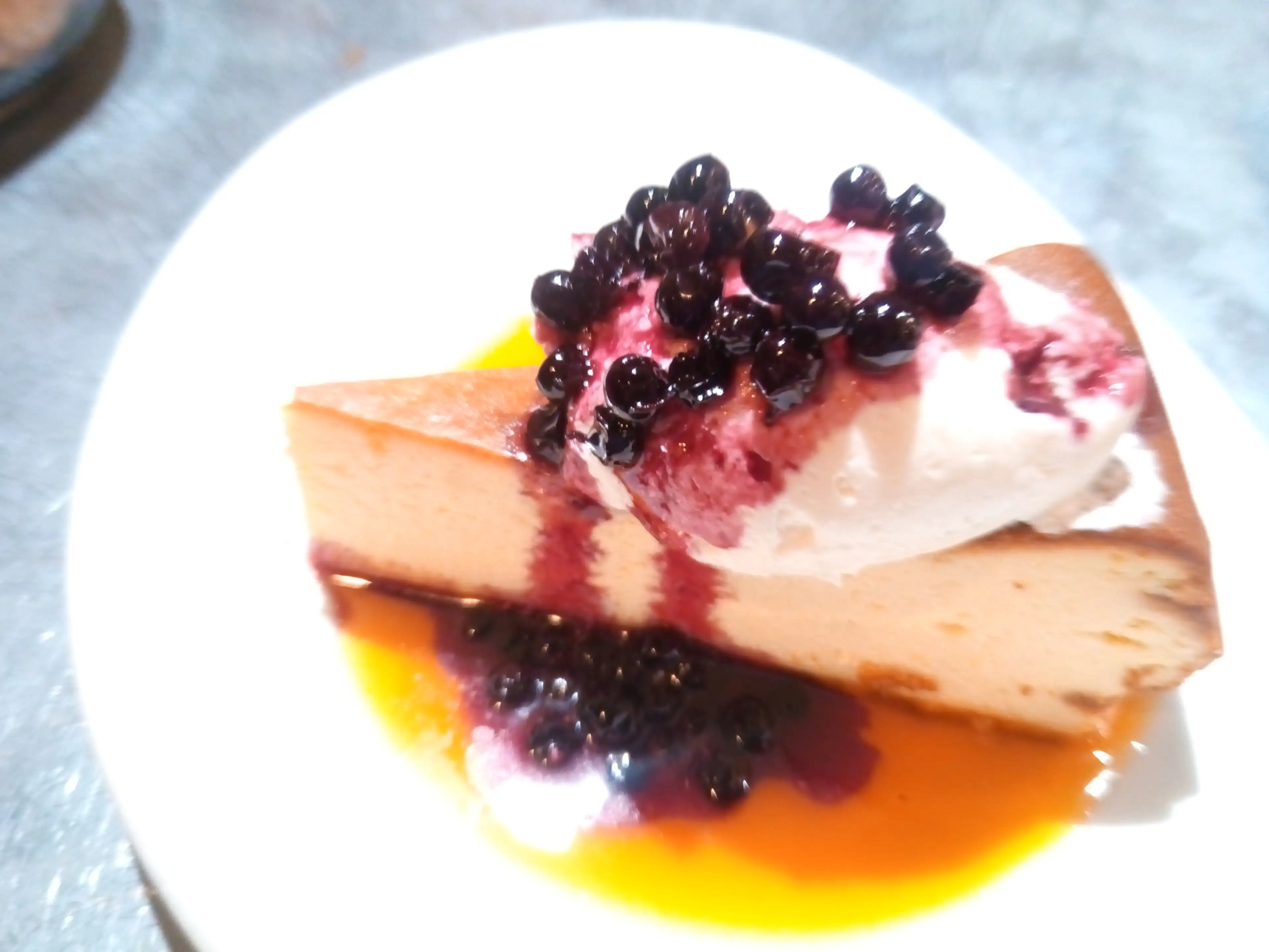 A slice of cake with blueberries on top.