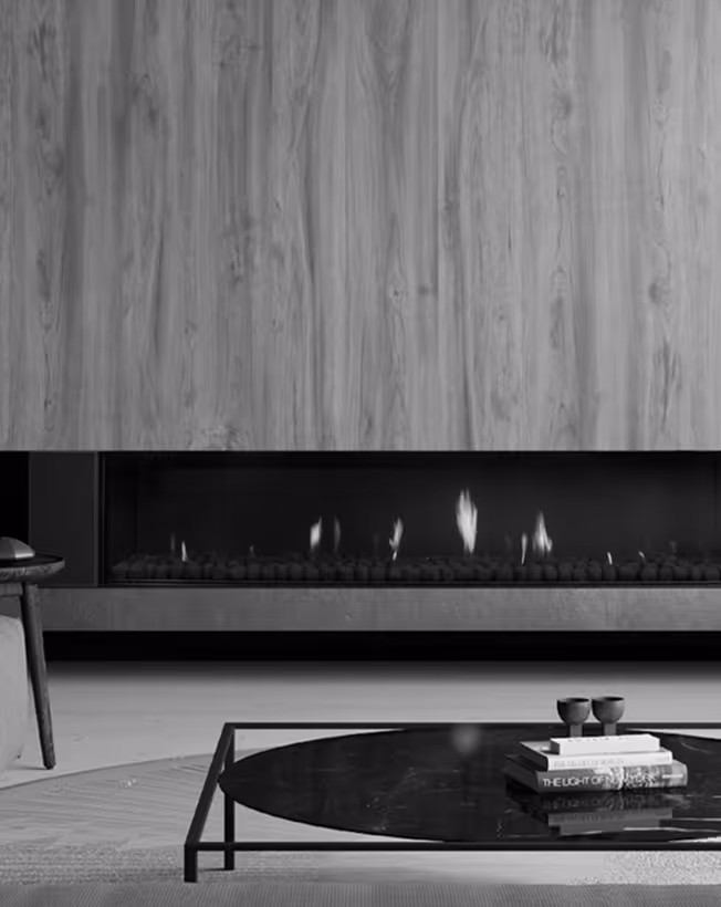 Modern living room with a sleek rectangular fireplace set below wood-paneled wall and a black round coffee table with books and cups.