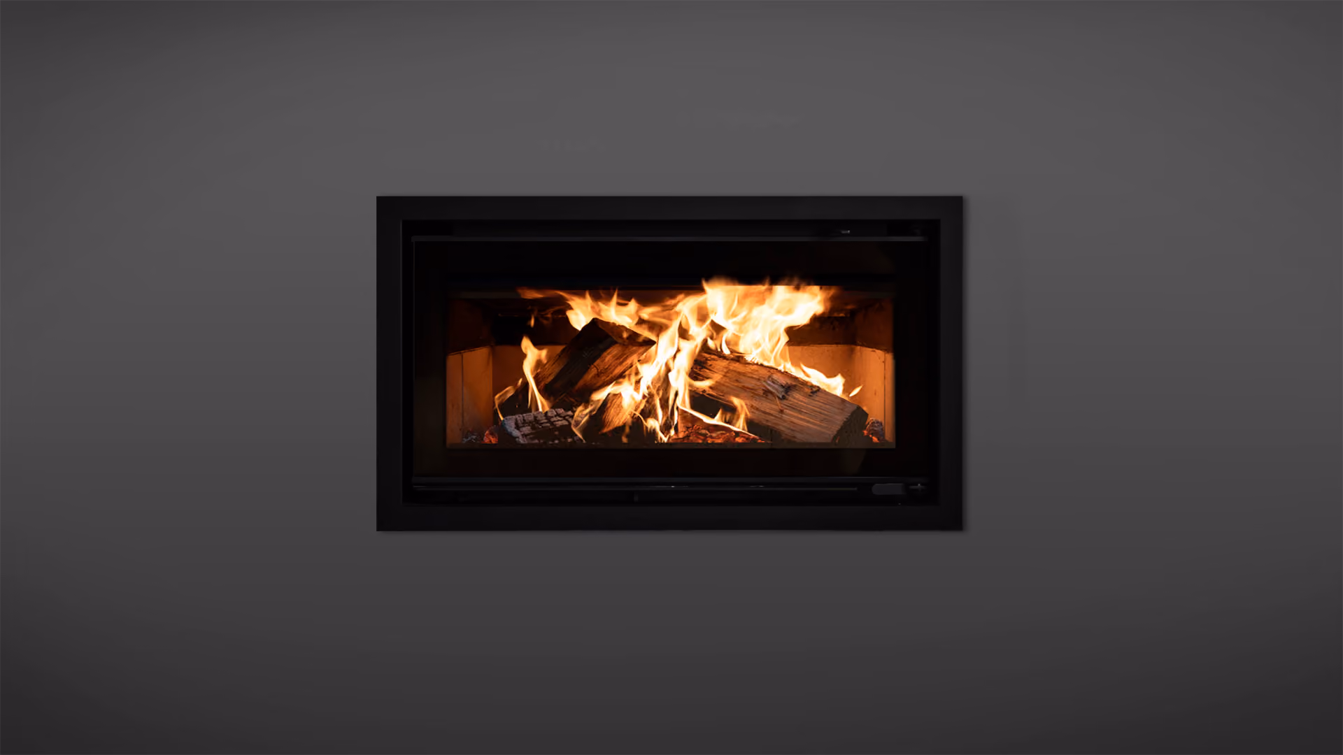 Modern gas fireplace with realistic burning logs set in a light-coloured wall next to a wooden side table with books.