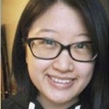 Smiling woman with black-framed glasses and straight dark hair.