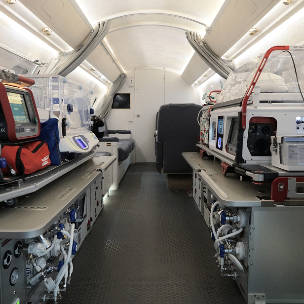 Interior of an airport medical evacuation aircraft with incubators, medical equipment, and seating.