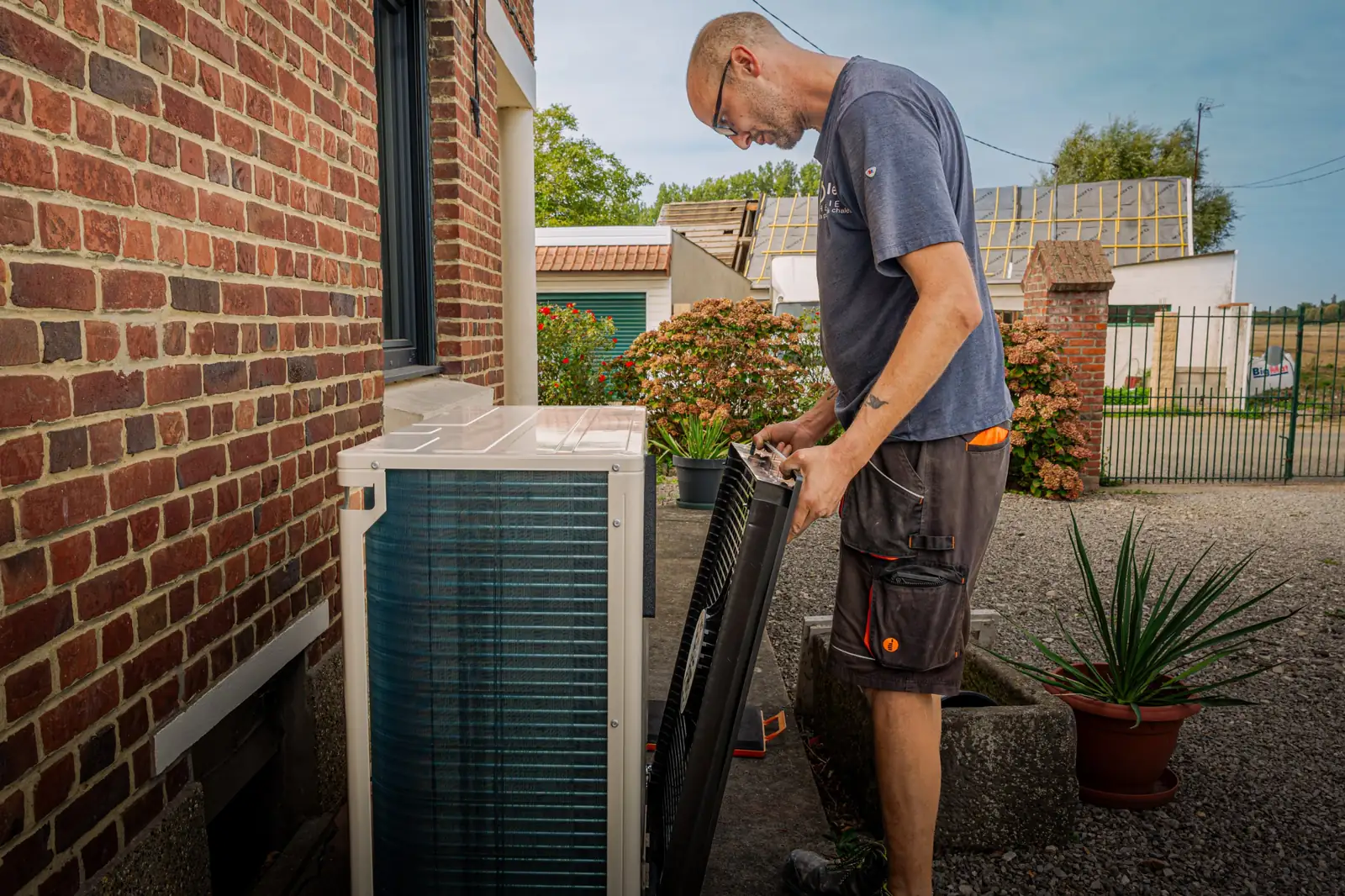 Pose d'une pompe à chaleur air-eau par un technicien Opale Géothermie chez un particulier