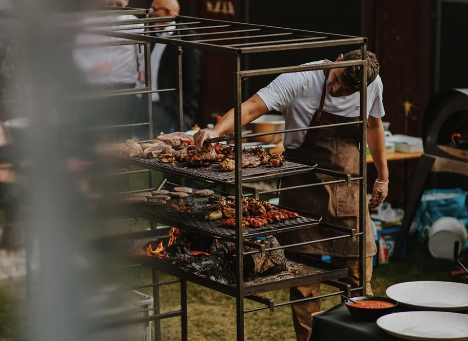 Professionele open vuur grill setup voor bedrijfsevents met meerdere roosters