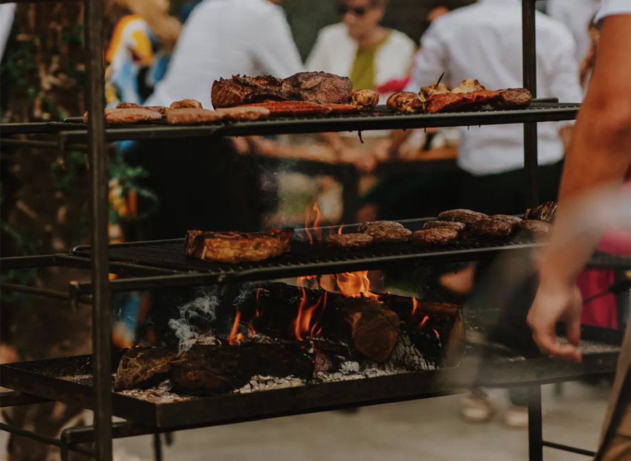 Bruiloft catering met open vuur BBQ en gezellige sfeerverlichting in tuin