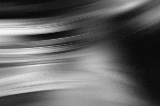 Abstract black and white image with blurred, flowing lines creating a smooth gradient effect.