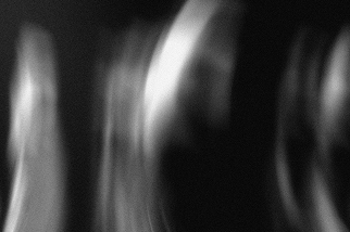 Abstract black and white image with blurred vertical and curved shapes.