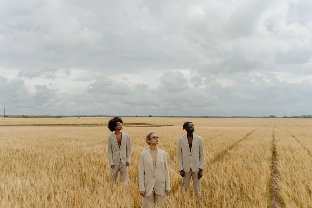Three models posing in a field.