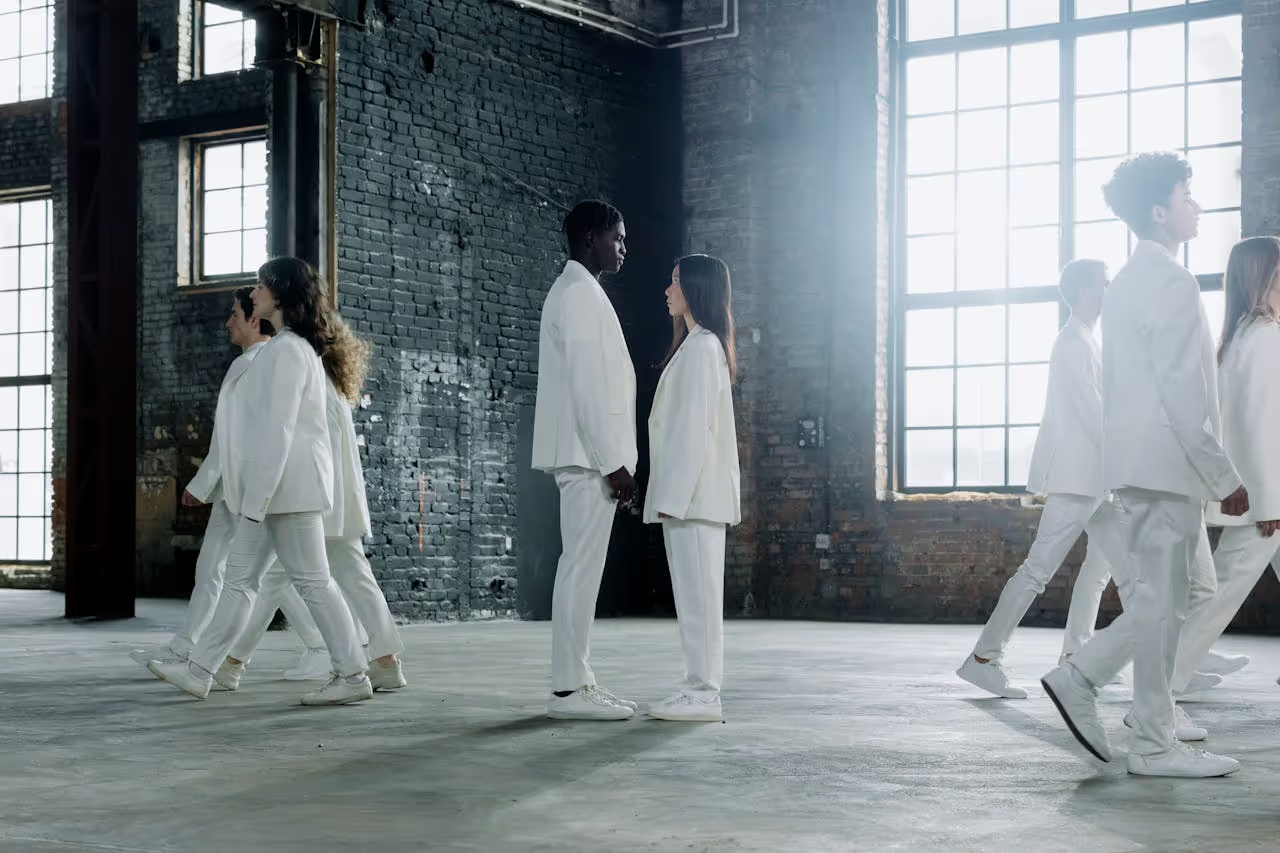 Man and woman dressing with white suits, facing each other.