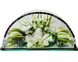 Decorative arrangement of white flowers and a small cherub statue under a half-circle glass dome.