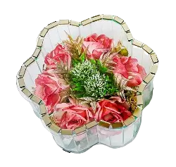 Flower-shaped glass container with pink roses and green foliage inside on a black background.