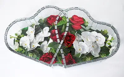 Two heart-shaped mirrors placed side by side reflecting a bouquet of cream roses and dark purple calla lilies with greenery.
