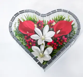 Heart-shaped glass box filled with small red and pink roses surrounding two large white roses in the center.