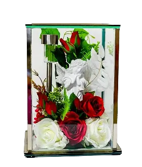Rectangular glass box with gold edges containing a floral arrangement of white, cream, and peach flowers with green leaves.