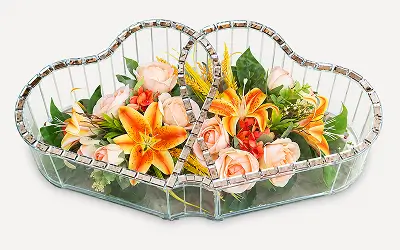 Two heart-shaped mirrors placed side by side reflecting a bouquet of cream roses and dark purple calla lilies with greenery.