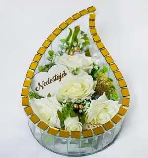 Arrangement of yellow and green sunflowers with small red flowers inside a teardrop-shaped frame with mirrored tiles.
