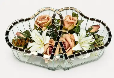 Two connected heart-shaped glass containers with red and white flowers inside.