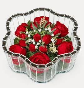 Red roses and white calla lilies arranged in a star-shaped glass vase.
