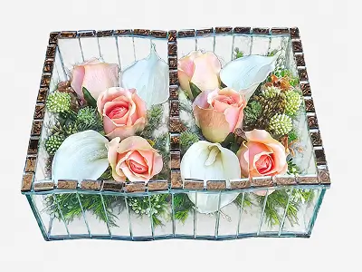 Two transparent glass containers with gold-tinted edges, each holding white and purple artificial flowers with green leaves.
