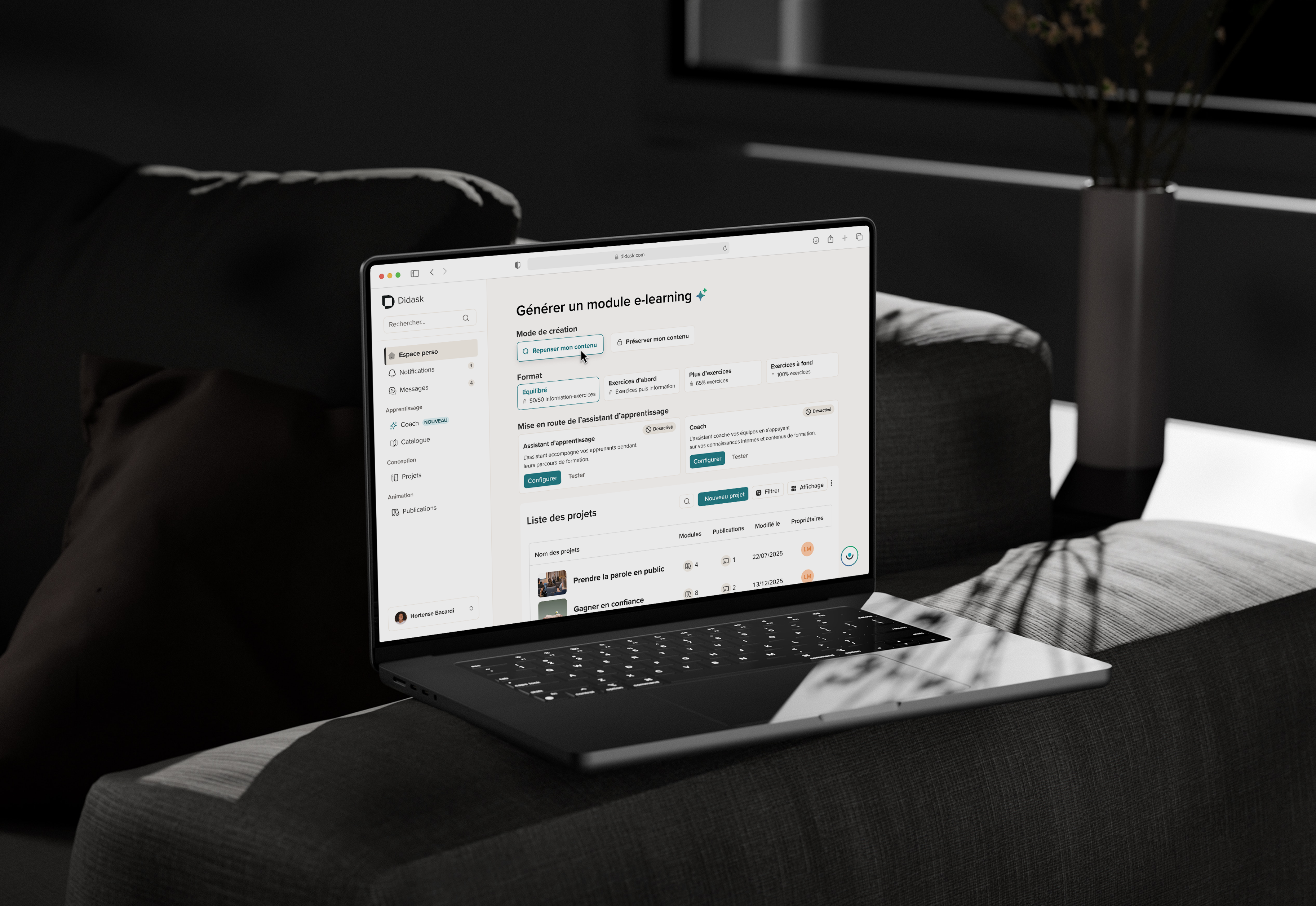 Ordinateur portable ouvert affichant la plateforme Didask avec un module e-learning sur un canapé gris dans une pièce sombre.