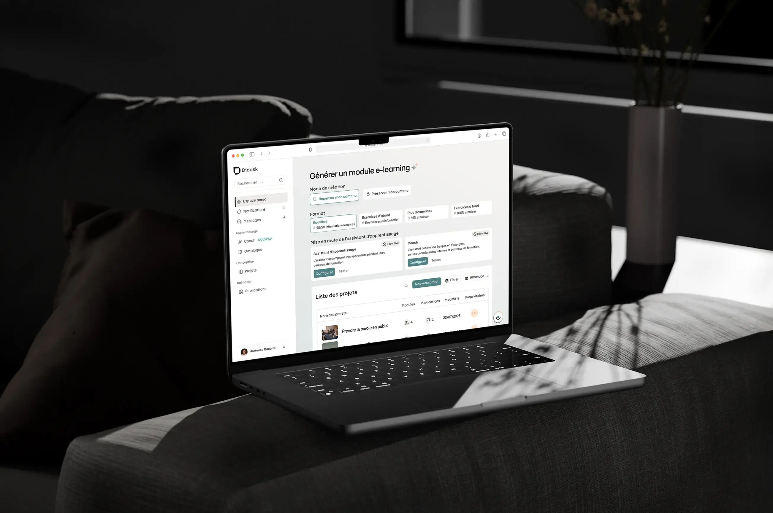 Ordinateur portable ouvert affichant la plateforme Didask avec un module e-learning sur un canapé gris dans une pièce sombre.