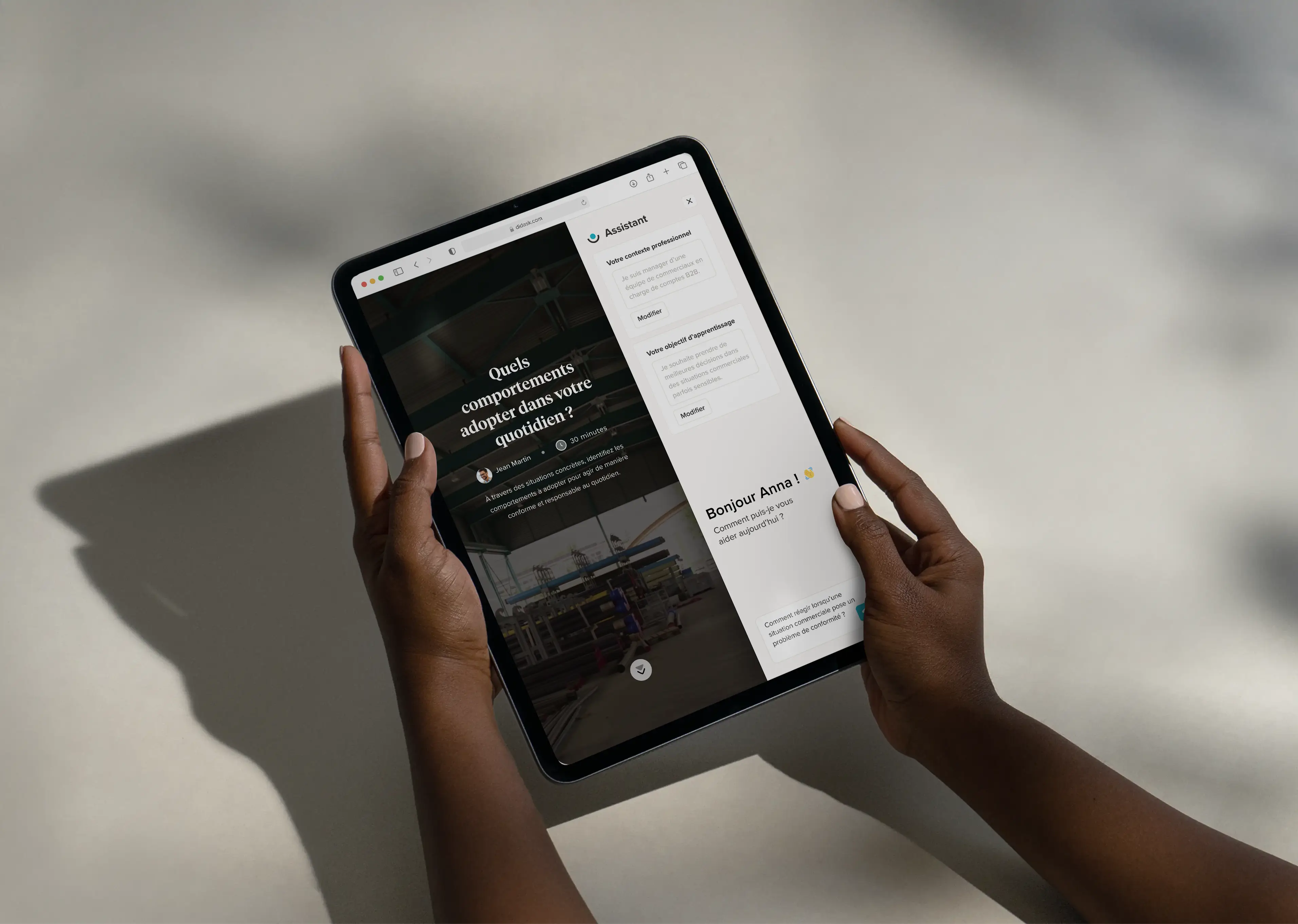 Personne tenant une tablette affichant une interface d'assistant en ligne en français, posant des questions sur les comportements à adopter au quotidien.