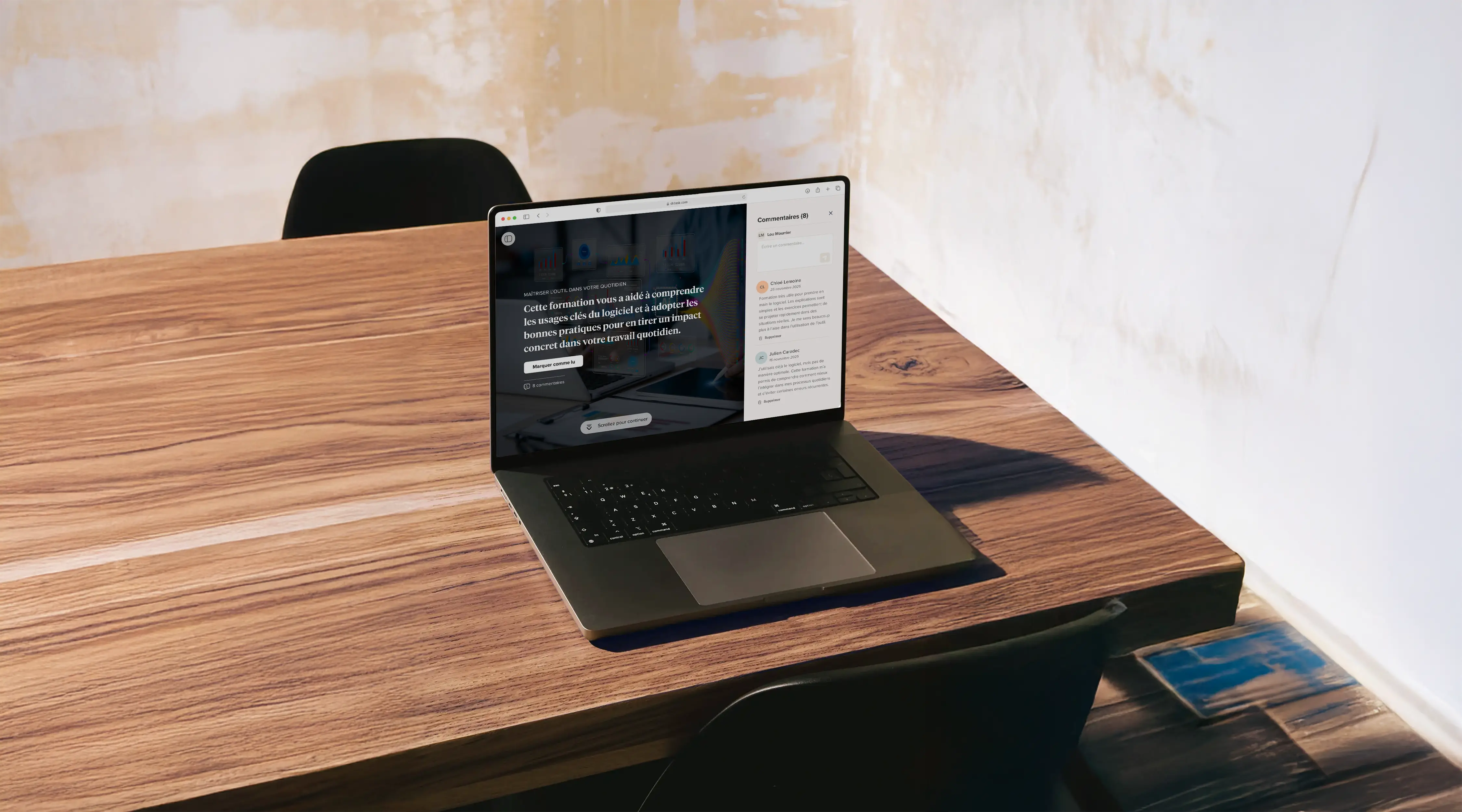 Ordinateur portable ouvert sur une table en bois avec un mur beige en arrière-plan.