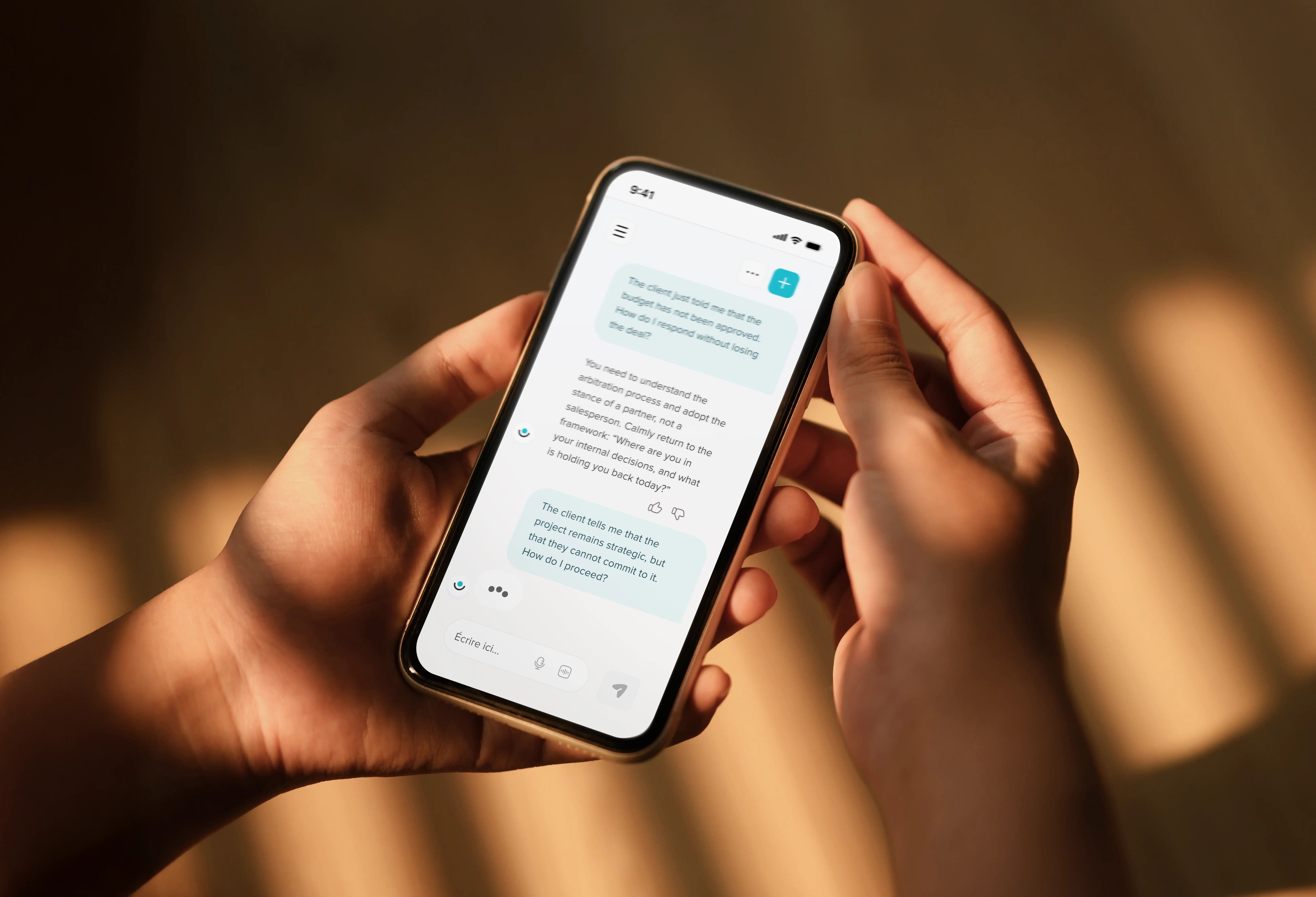 Phone on a table showing a Didask sales coaching chat conversation in French about handling client objections during meetings.