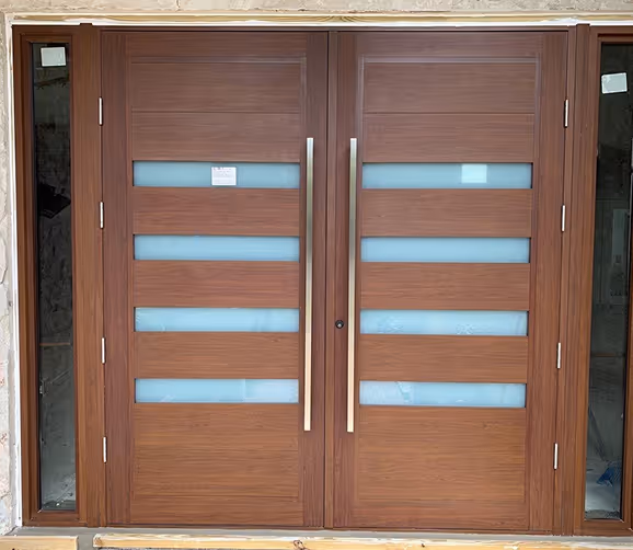 Modern double wooden door with horizontal frosted glass panels and long vertical metal handles.