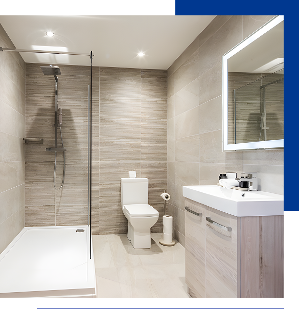 Modern bathroom with a walk-in shower, white toilet, light wood vanity, and a backlit rectangular mirror.