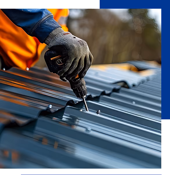 Person wearing gloves using a cordless drill to fasten screws on a metal roof.
