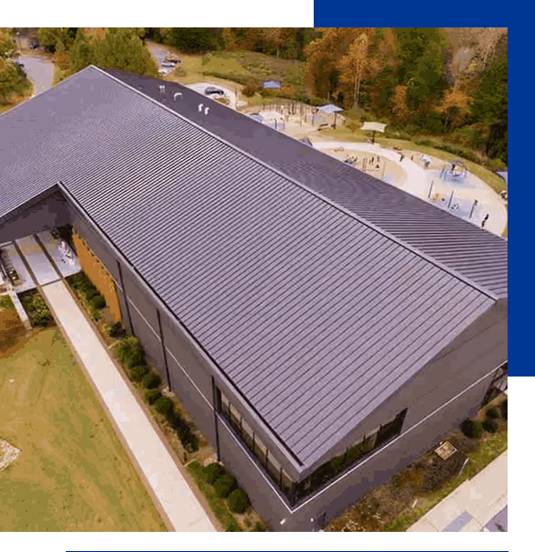 A professional commercial roofing project with a black standing seam metal roof installation