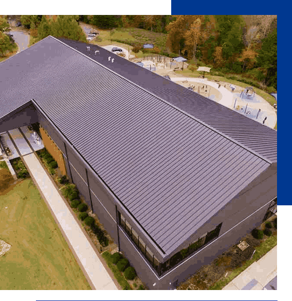 A professional commercial roofing project with a black standing seam metal roof installation