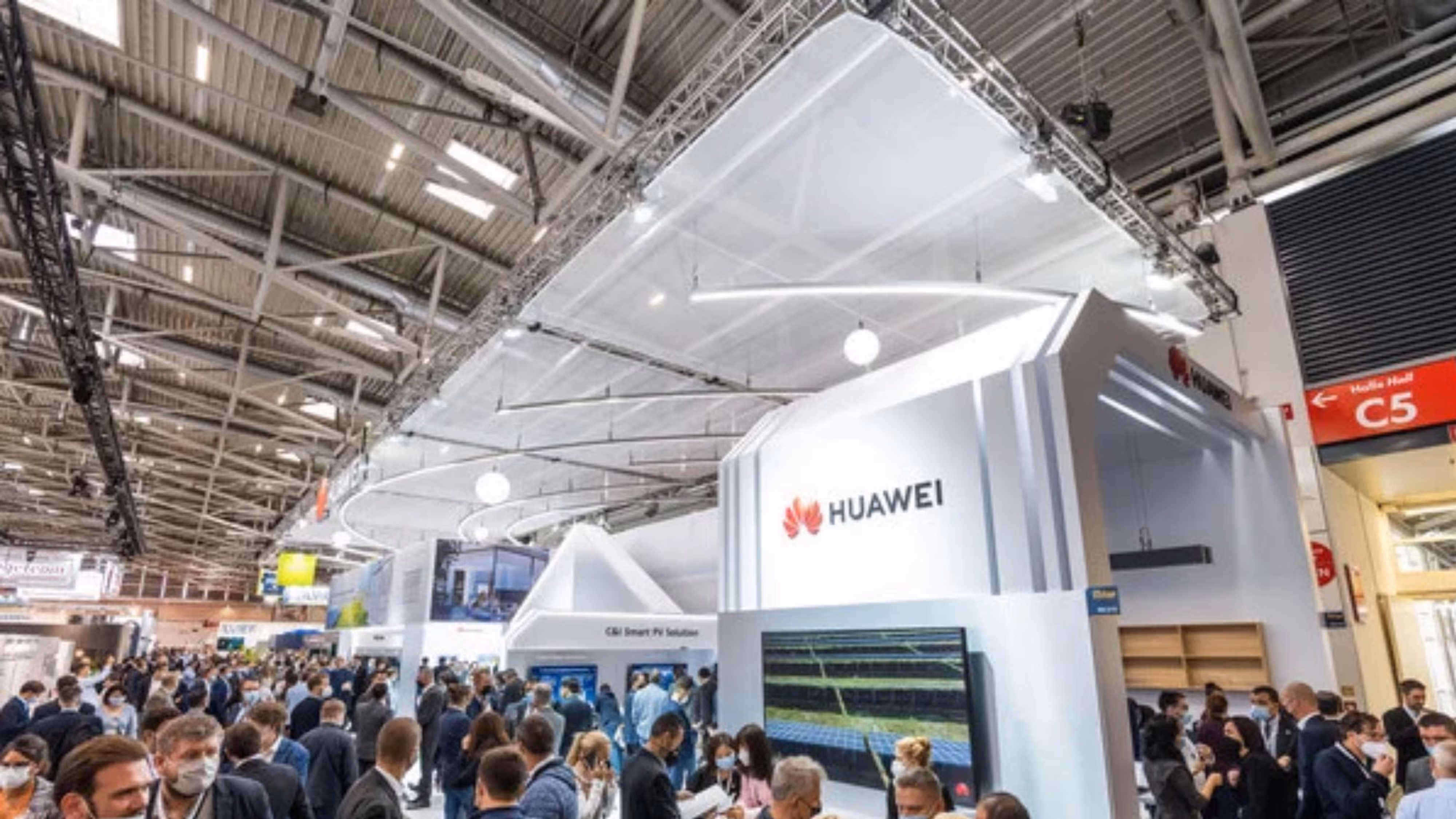 Tłum ludzi odwiedzających stoisko Huawei na targach w hali wystawowej .